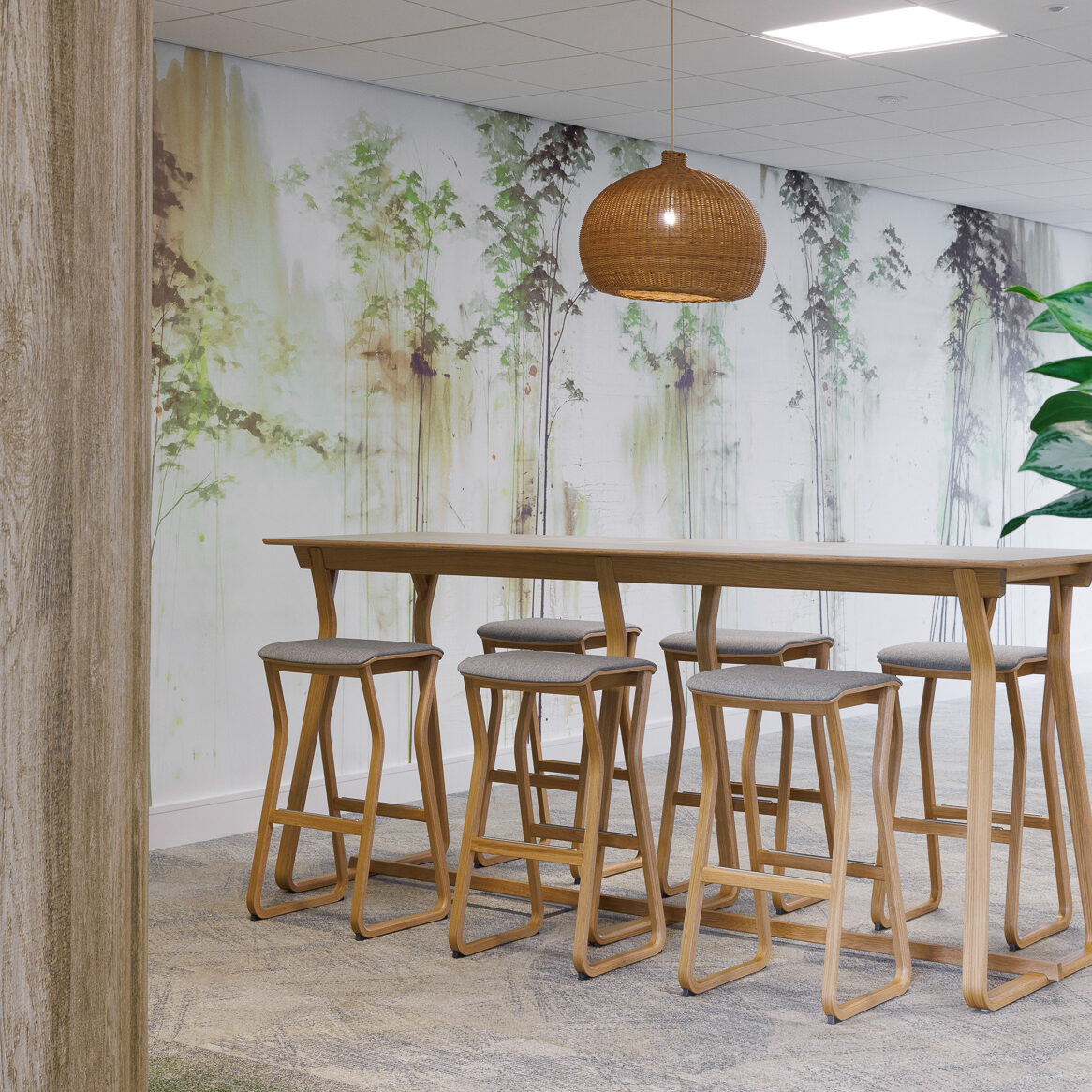 Wooden high table and high stools in green office space